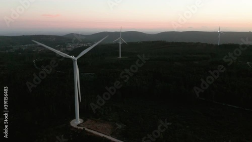 Wind Turbines Producing Energy With Silhouettes At The Background In Serra de Aire e Candeeiros, Leiria Portugal. - Aerial Shot photo