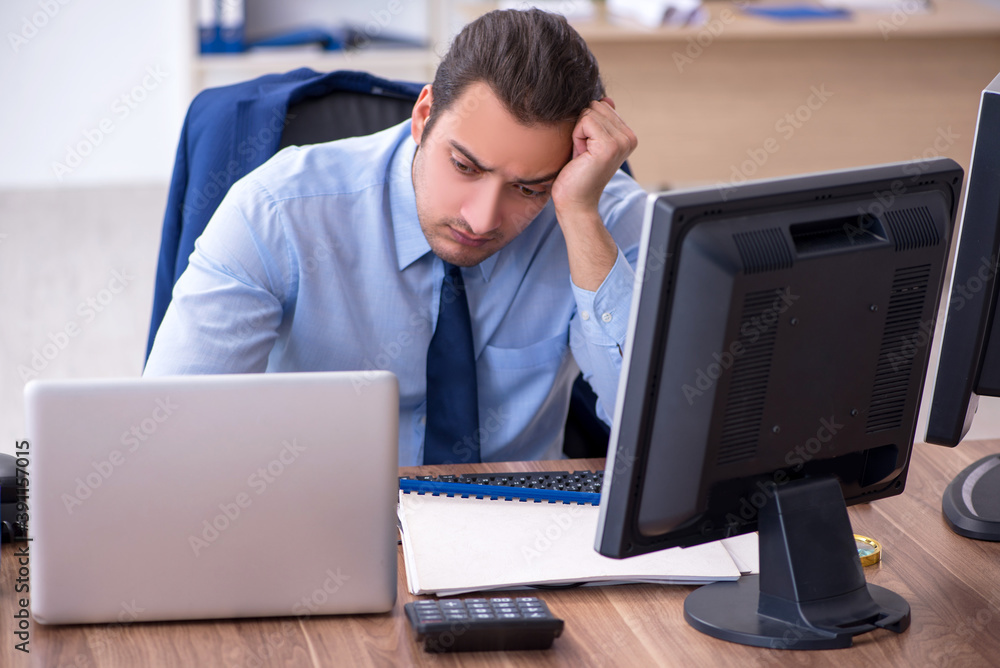 Young male employee unhappy with excessive work Young male employee unhappy with excessive work