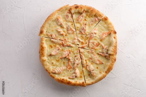 Appetizing pizza with salmon on a light textured background. Delicious food concept. Close-up.