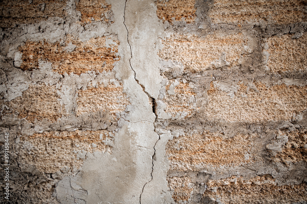 Fototapeta premium Rough texture of a brick wall made of shells. There is a crack in the middle of the wall.