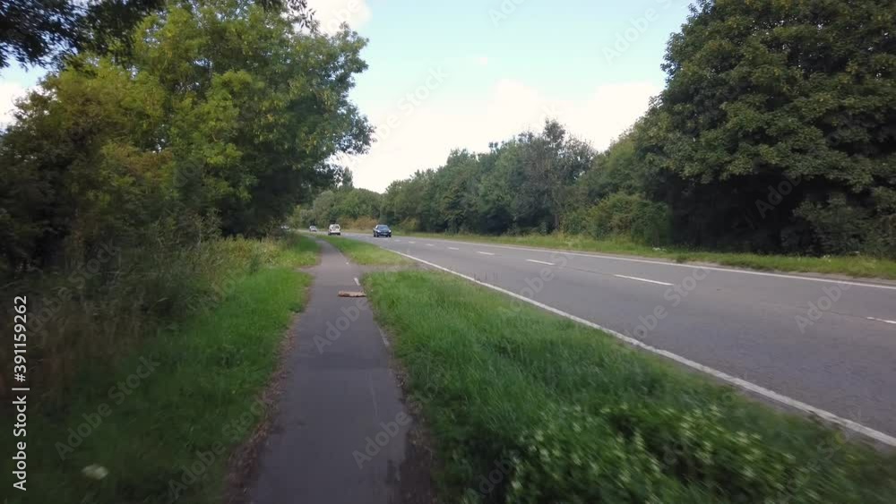Cycling from Oxford next to a less busy road on a cloudy day, handheld. Cycling from Oxford next to a less busy road on a cloudy day, handheld.