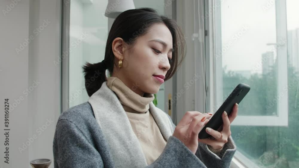 Close up 4k slow motion of happy young Chinese girl looking at mobile phone smile beautiful asian woman browsing online using phone and laugh Close up 4k slow motion of happy young Chinese girl looking at mobile phone smile beautiful asian woman browsing online using phone and laugh