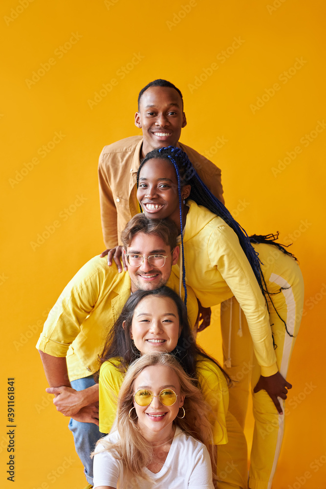 studio shoot of encouraged models of diverse races isolated on yellow background, beautiful guys and ladies happy to be in one group, team, country, friendship concept