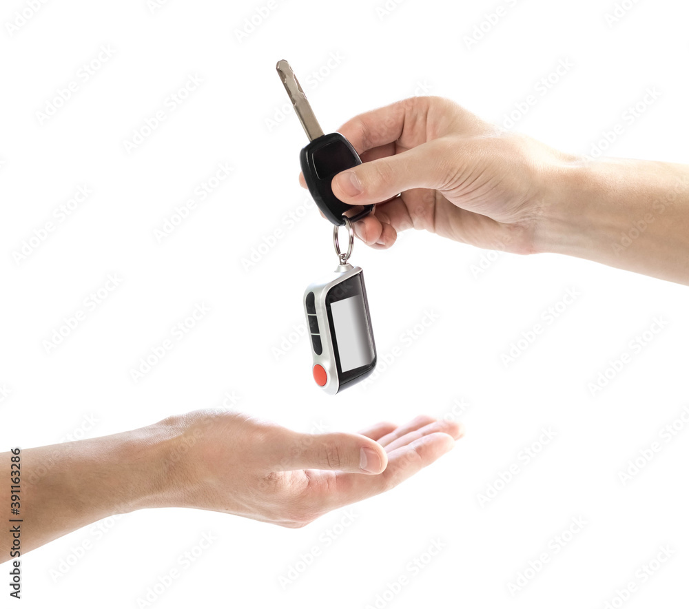 The hand passes the car keys to the other hand. Close up. Isolated on a white background The hand passes the car keys to the other hand. Close up. Isolated on a white background