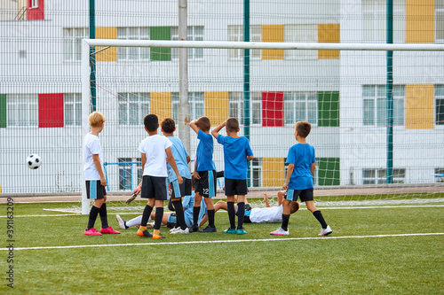 teen boys training soccer or football game in stadium, sportive children kick ball, practice penalty and other tricks © Roman