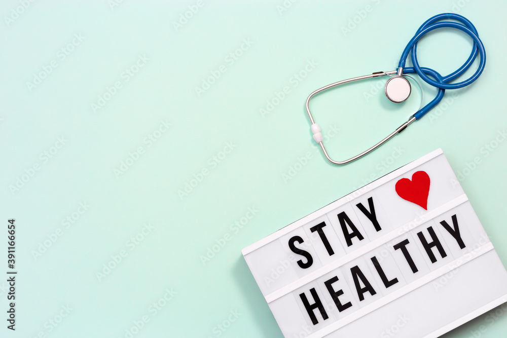 Lightbox with words Stay Healthy and blue stethoscope. Care of health and medical concept. World health day. Lightbox with words Stay Healthy and blue stethoscope. Care of health and medical concept. World health day.