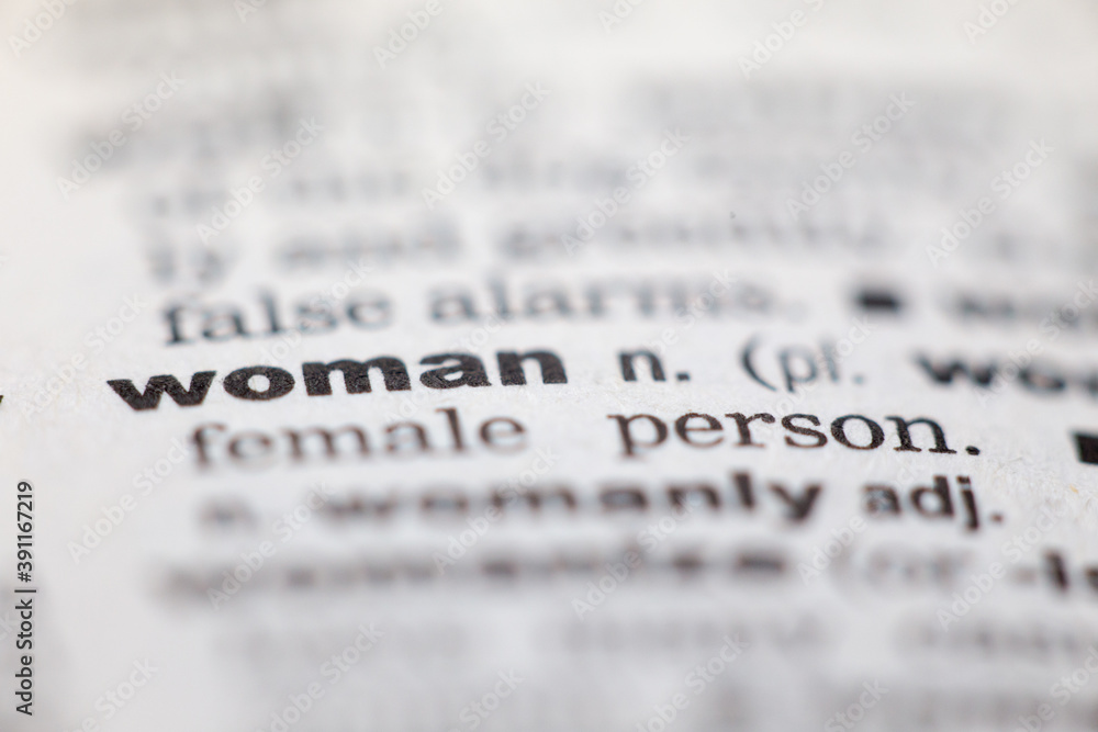 Macro close up of old English dictionary page with word woman Macro close up of old English dictionary page with word woman