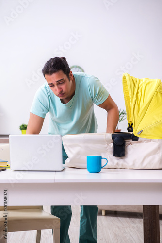 Young male parent looking after newborn at home