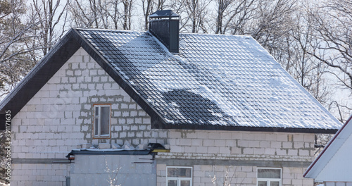 Snow on the roof of the house.