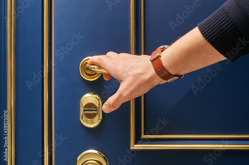 Classic wood entrance door in dark blue with carved panels and gold patina