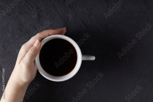Coffee cup in hand on concrete table. Top view with copy space.