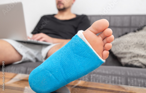 Close up of male foot in plaster cast with blue splint.