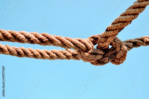 Rope and blue sky background.  A rope tied off as sailor's knot.