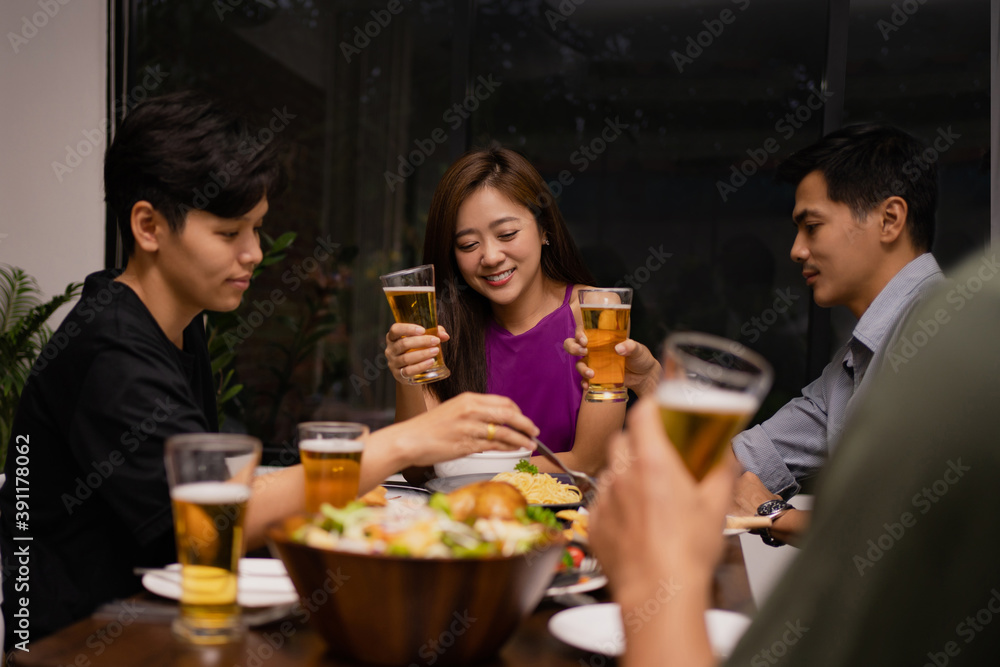 Working group of young Asians drinking beer and clink glasses in a restaurant. They're relaxed. Working group of young Asians drinking beer and clink glasses in a restaurant. They're relaxed.
