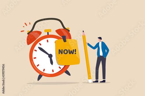 Stop procrastination, do it now or decision to finish work or appointment in time concept, confidence businessman holding pencil after he wrote the word Now on note and stick it on ringing alarm clock photo