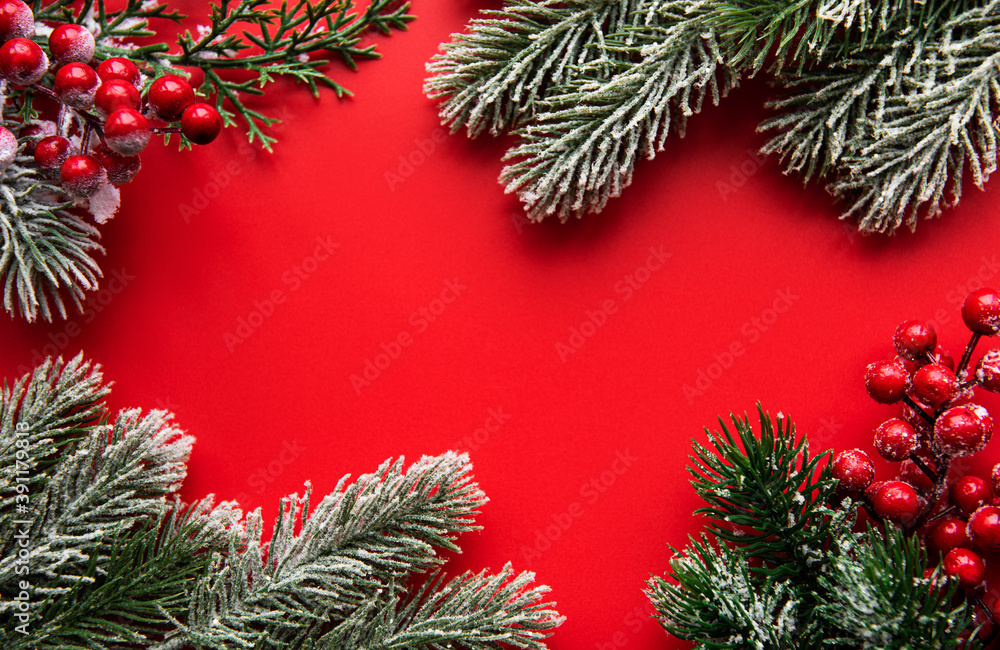 Christmas red decorations, fir tree branches on red background Christmas red decorations, fir tree branches on red background