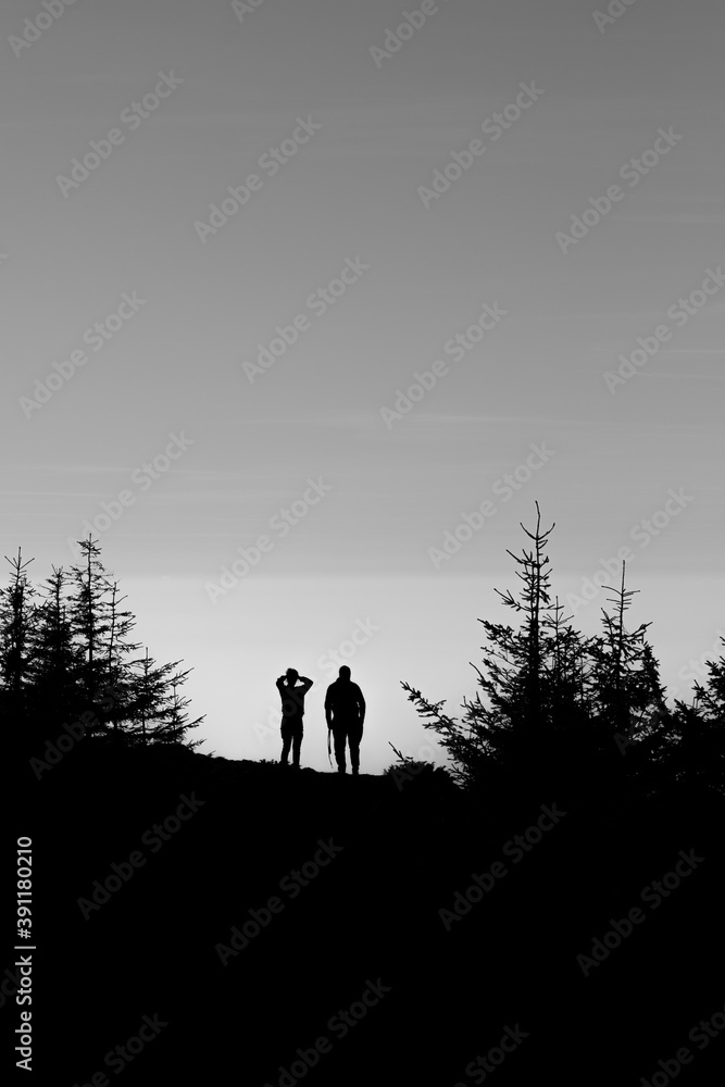 Silouhette of two people staring at the sky in nature Silouhette of two people staring at the sky in nature