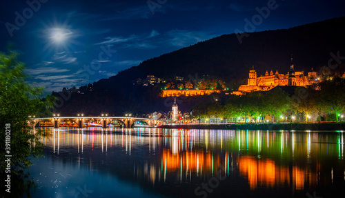 Panoramic view of the old town of Heidelberg reflecting in beautiful Neckar river at night