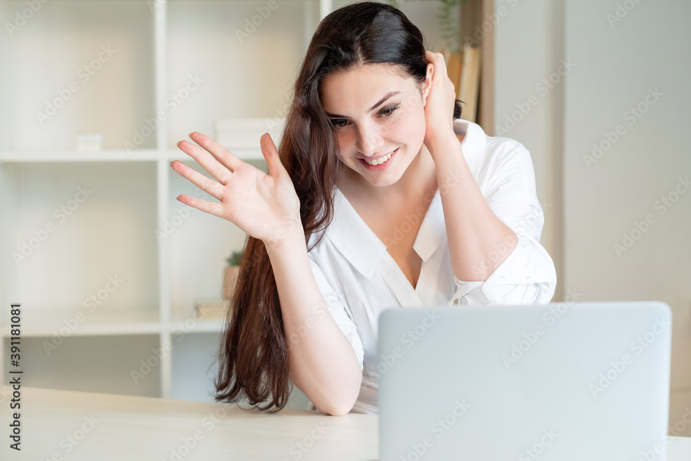Online conference. Virtual meeting. Videochat call. Digital technology. Happy woman greeting somebody looking laptop light home office interior background. Online conference. Virtual meeting. Videochat call. Digital technology. Happy woman greeting somebody looking laptop light home office interior background.