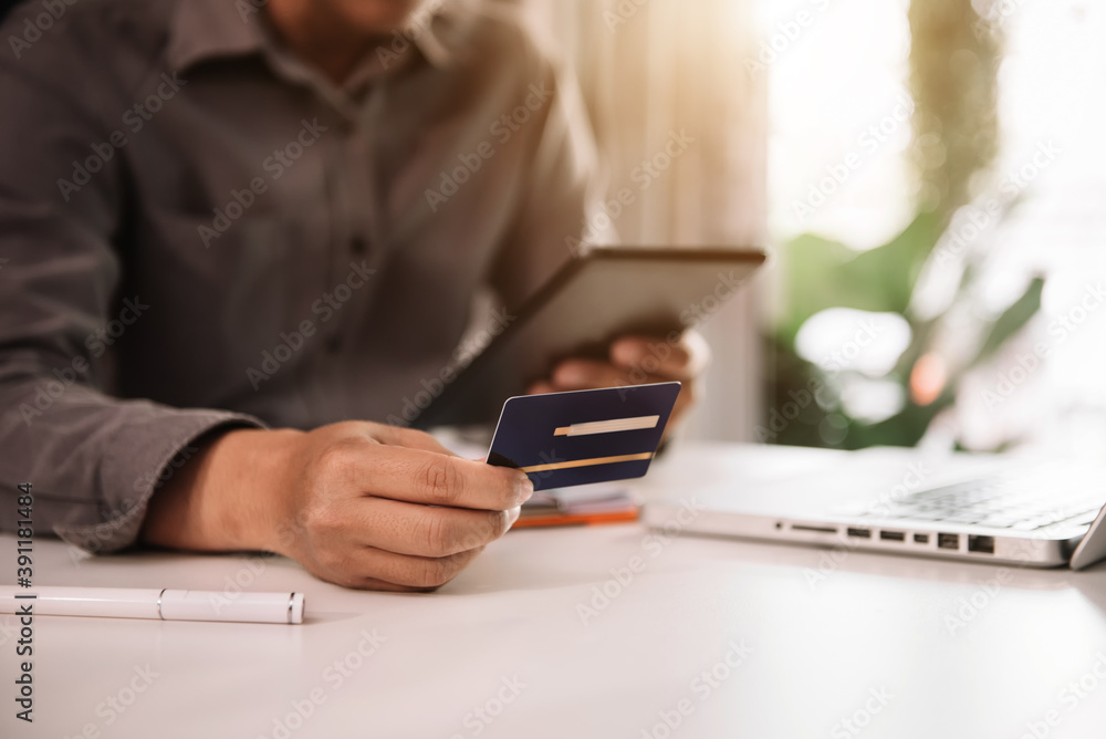 Male businessman use credit cards to conduct financial transactions through phones, tablet, and laptop. Male businessman use credit cards to conduct financial transactions through phones, tablet, and laptop.