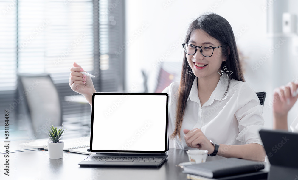 Young asian woman with glasses using tablet computer presenting her business plan while sitting in meeting room. Young asian woman with glasses using tablet computer presenting her business plan while sitting in meeting room.