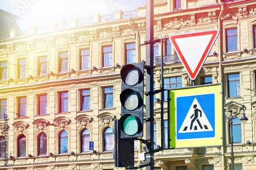 Traffic light and road signs on old city building