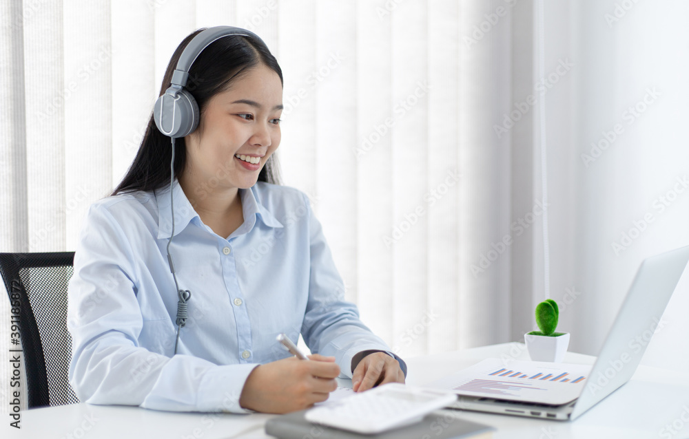 Young white Asian woman studying via the internet in her home office. Young white Asian woman studying via the internet in her home office.