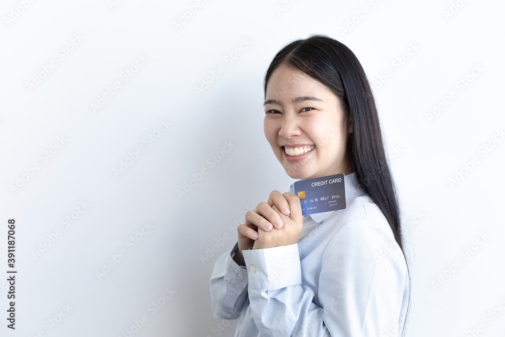 White Asian woman holding a credit card and smiling bright White Asian woman holding a credit card and smiling bright