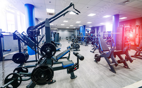 Interior of modern gym with dumbbells and adjustable versatile weight benches. No people. Modern fitness center.