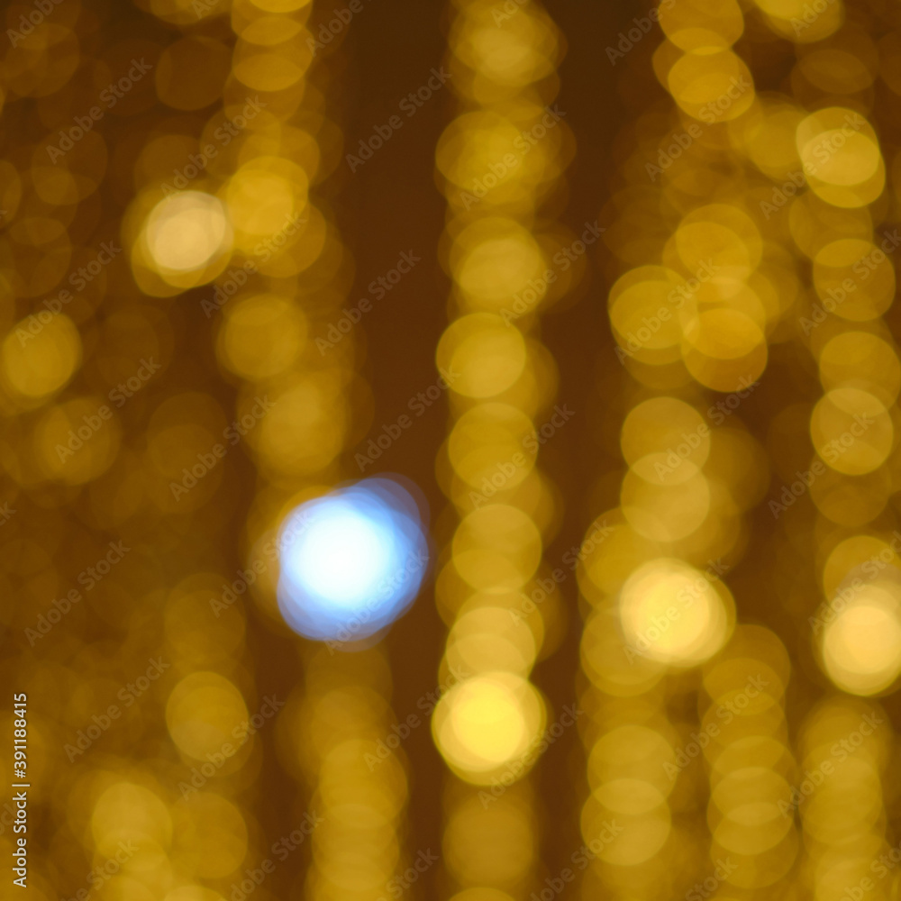 Fototapeta premium Blurred light background of christmas garlands, golden bokeh of city street lamps
