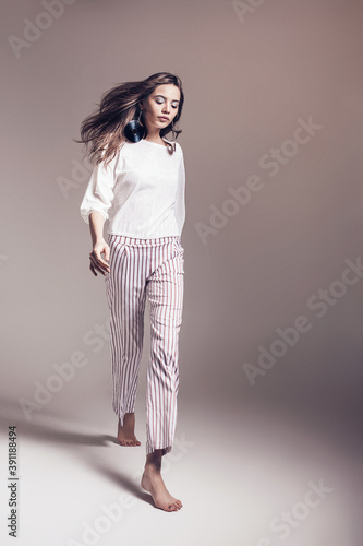Walking woman in striped pants and white top