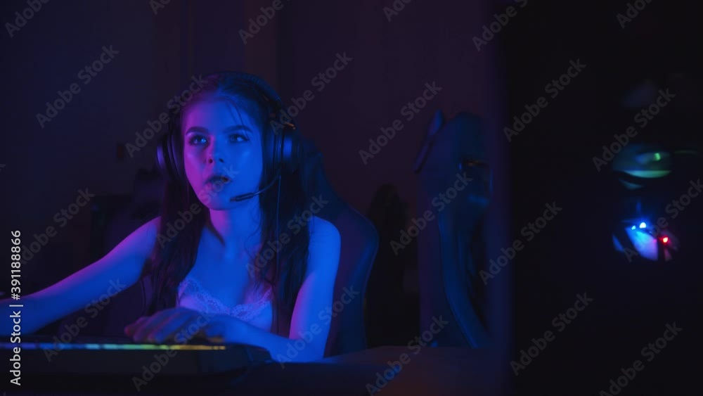 Two beautiful gamer girls playing an online game in the neon gaming club Two beautiful gamer girls playing an online game in the neon gaming club