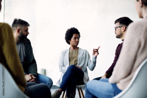Fototapeta Naklejka Na Ścianę i Meble -  Mid adult black woman communicating with support group during psychotherapy.