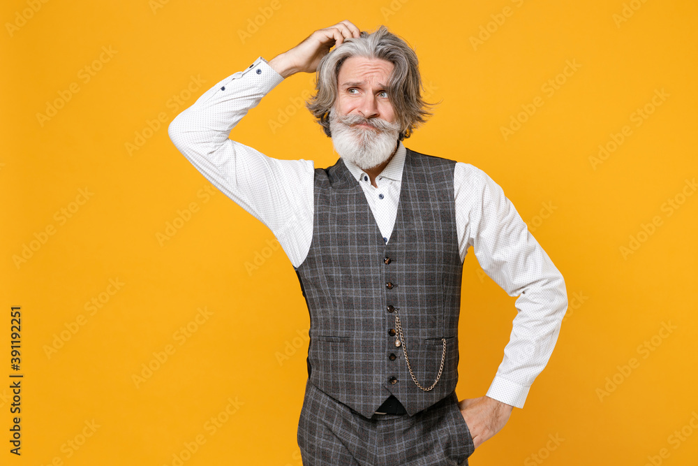 Preoccupied elderly gray-haired mustache bearded business man in checkered suit waistcoat white shirt put hand on head isolated on yellow background studio portrait. Achievement career wealth concept. Preoccupied elderly gray-haired mustache bearded business man in checkered suit waistcoat white shirt put hand on head isolated on yellow background studio portrait. Achievement career wealth concept.