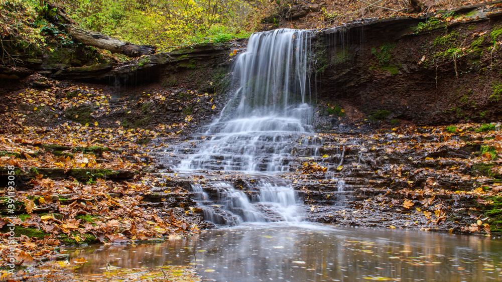 Fototapeta premium Colorful majestic waterfall in national park forest during autumn
