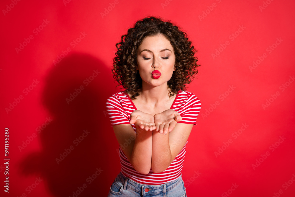Photo of lovely wavy young woman dressed striped outfit sending you kiss closed eyes isolated red color background Photo of lovely wavy young woman dressed striped outfit sending you kiss closed eyes isolated red color background