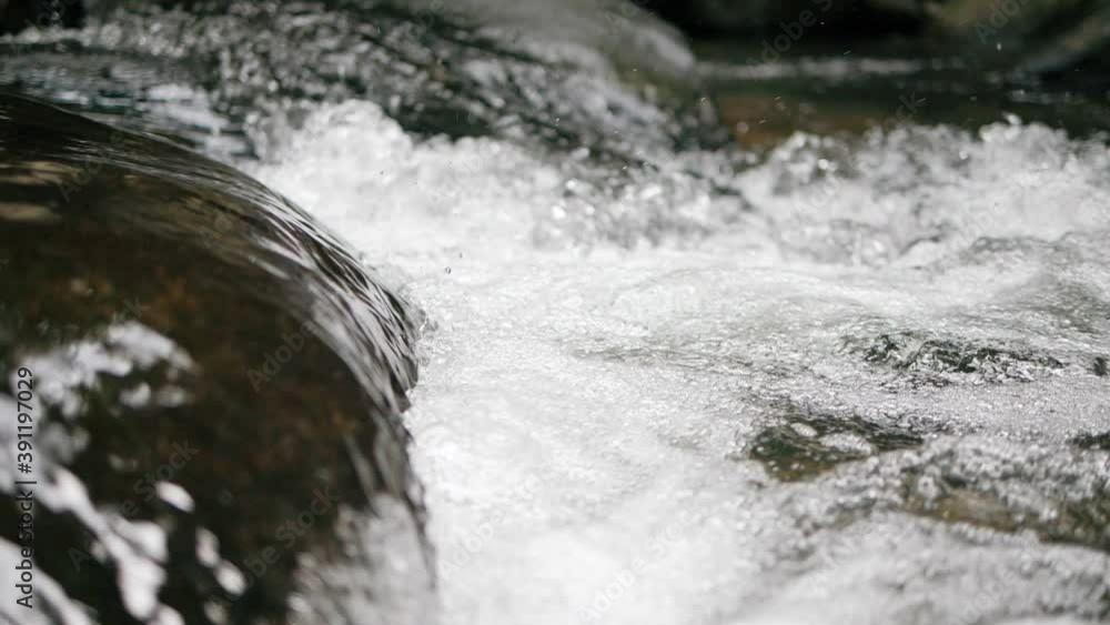 Slow motion of wild mountain river abundant clear stream flowing through rocks. Close-up of river rocks with flowing water. Close up Slow motion of wild mountain river abundant clear stream flowing through rocks. Close-up of river rocks with flowing water. Close up