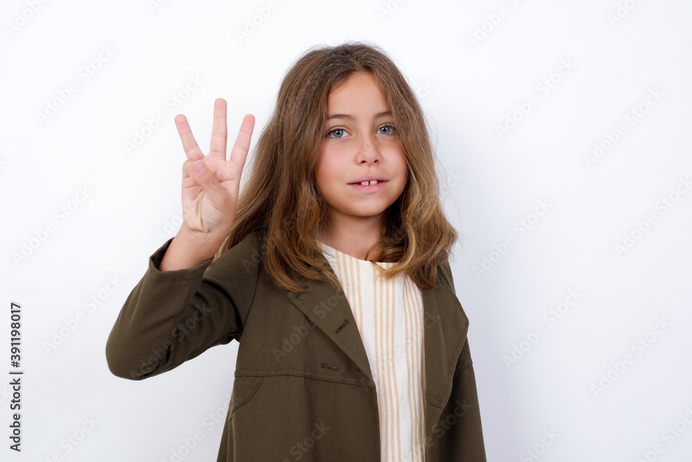 Beautiful little girl standing against white background, showing and pointing up with fingers number three while smiling confident and happy. Beautiful little girl standing against white background, showing and pointing up with fingers number three while smiling confident and happy.
