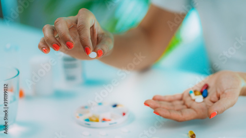 Female patient counting pills. Medicine non-adherence.