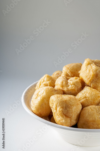 Close-up of a bowl of golden tempting fried tofu with avocado oil