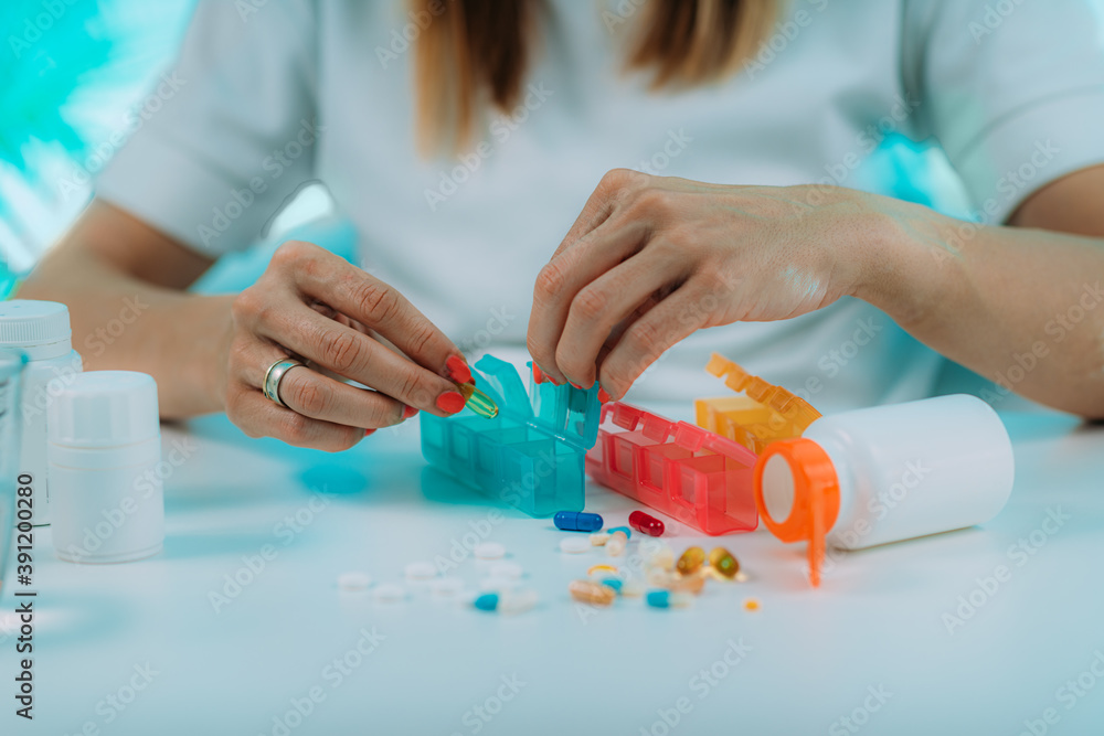 Medicine non adherence. Woman holding pills in her hand, not sure if she had taken the medicine or not - obrazy, fototapety, plakaty 
