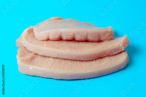 fresh turkey steaks on blue background