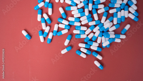 white and blue pills on red background
