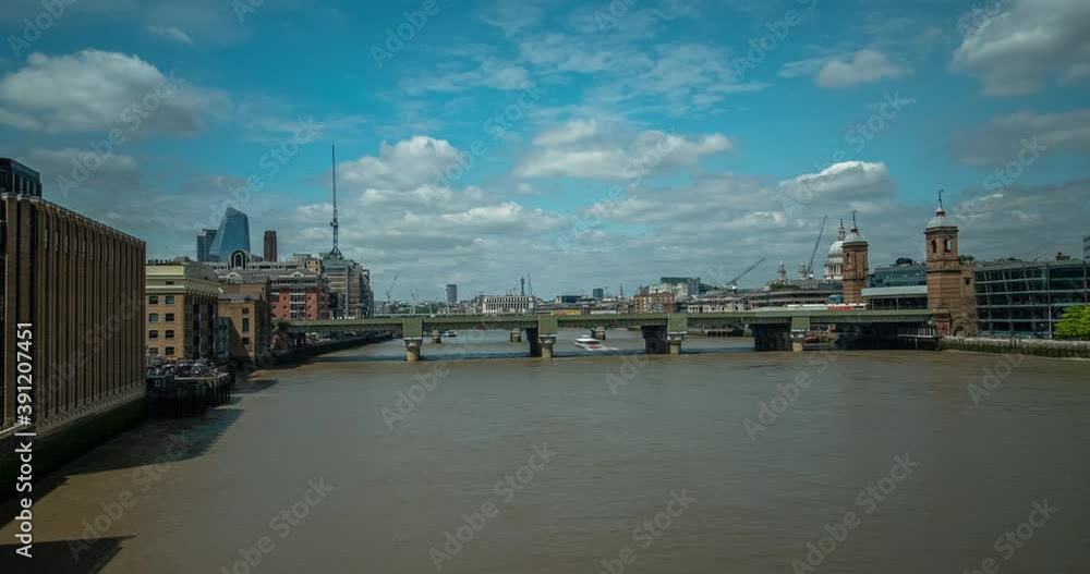 Timelapse of the river Thames from London Bridge during the day, clouds roll in a brilliant blue sky and ferries take passengers. Trains cross over on a distant rail bridge. Timelapse of the river Thames from London Bridge during the day, clouds roll in a brilliant blue sky and ferries take passengers. Trains cross over on a distant rail bridge.