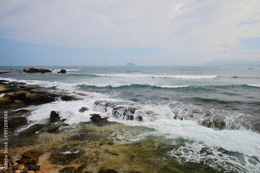From Guihou Coast, you can see the beautiful Keelung Island bathed in blue sky and white clouds. The waves slapped against the rocky shore.