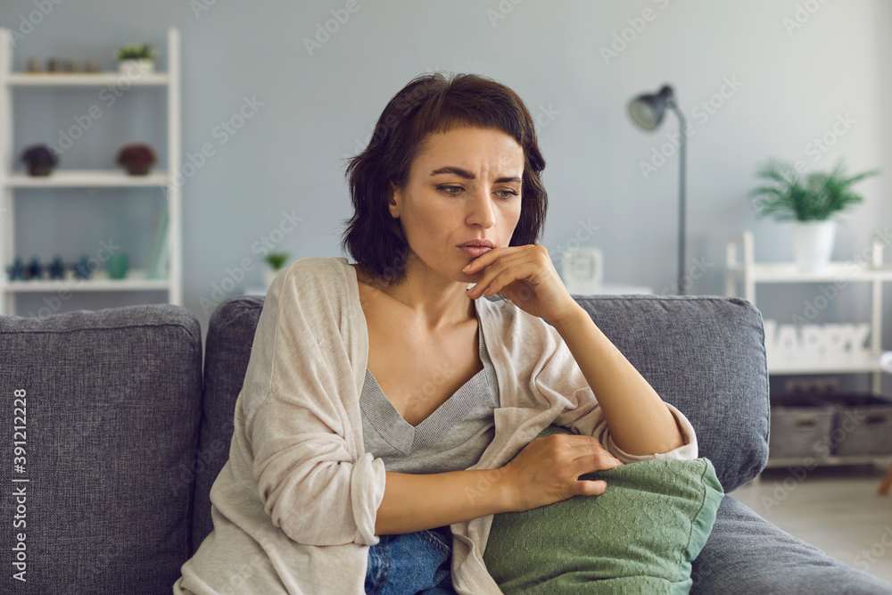 Young woman feeling frustrated touching chin during online meeting Young woman feeling frustrated touching chin during online meeting