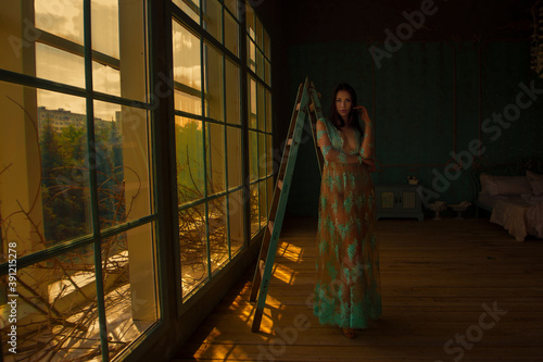 Beautiful woman in the sunset with the window