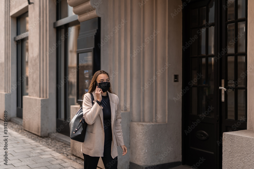 Girl walking with face mask and calling on her phone. Autumn city mood. Covid-19. Girl walking with face mask and calling on her phone. Autumn city mood. Covid-19.