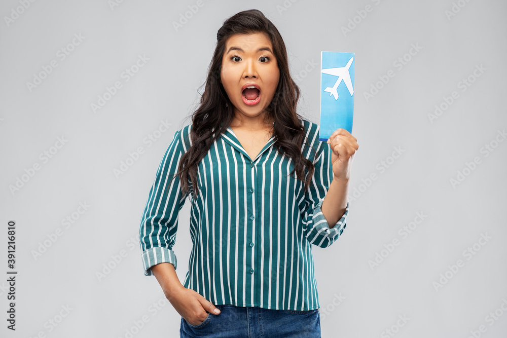 travel, tourism and vacation concept - surprised young asian woman with air ticket over grey background travel, tourism and vacation concept - surprised young asian woman with air ticket over grey background