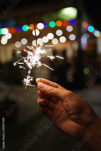 Cropped Image Of Female Hand Holding Sparkler At Night